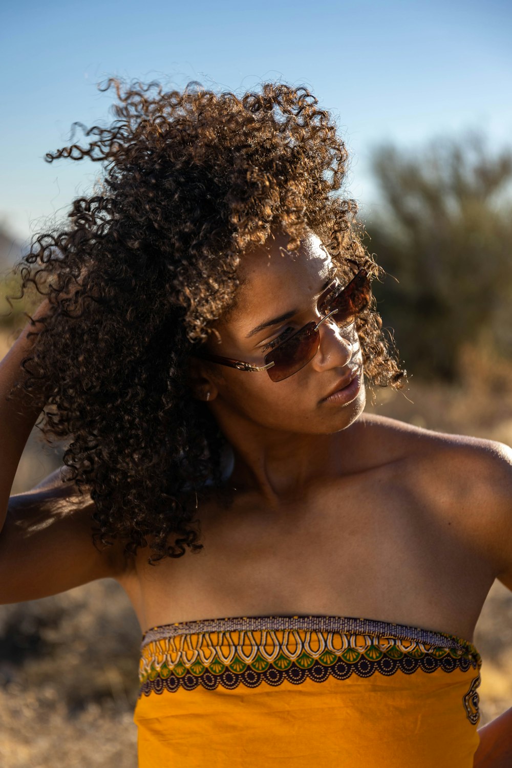 a woman in a yellow dress and sunglasses