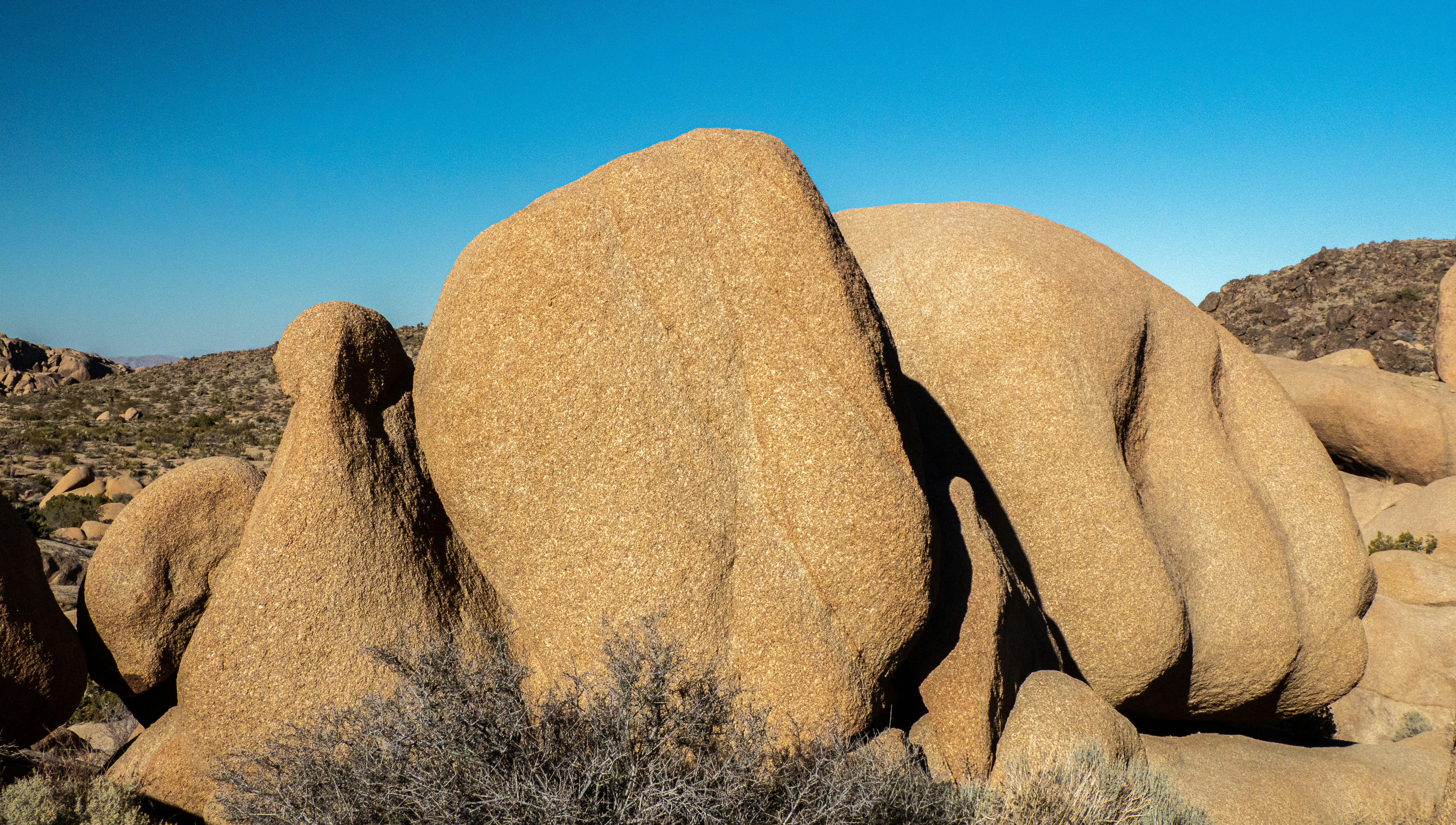 Un gros rocher au milieu d’un désert photo Photo Bleu Gratuite sur