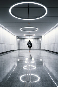 a man is walking down a long hallway