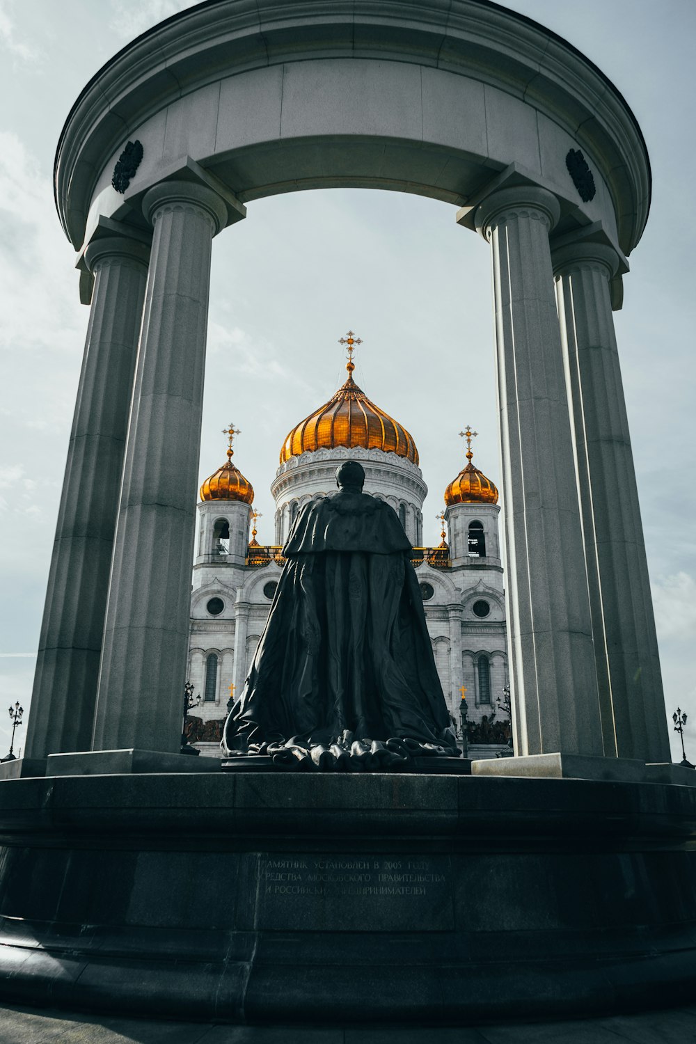a statue in front of a building with a golden dome