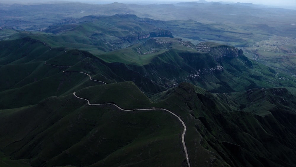 an aerial view of a winding road in the mountains