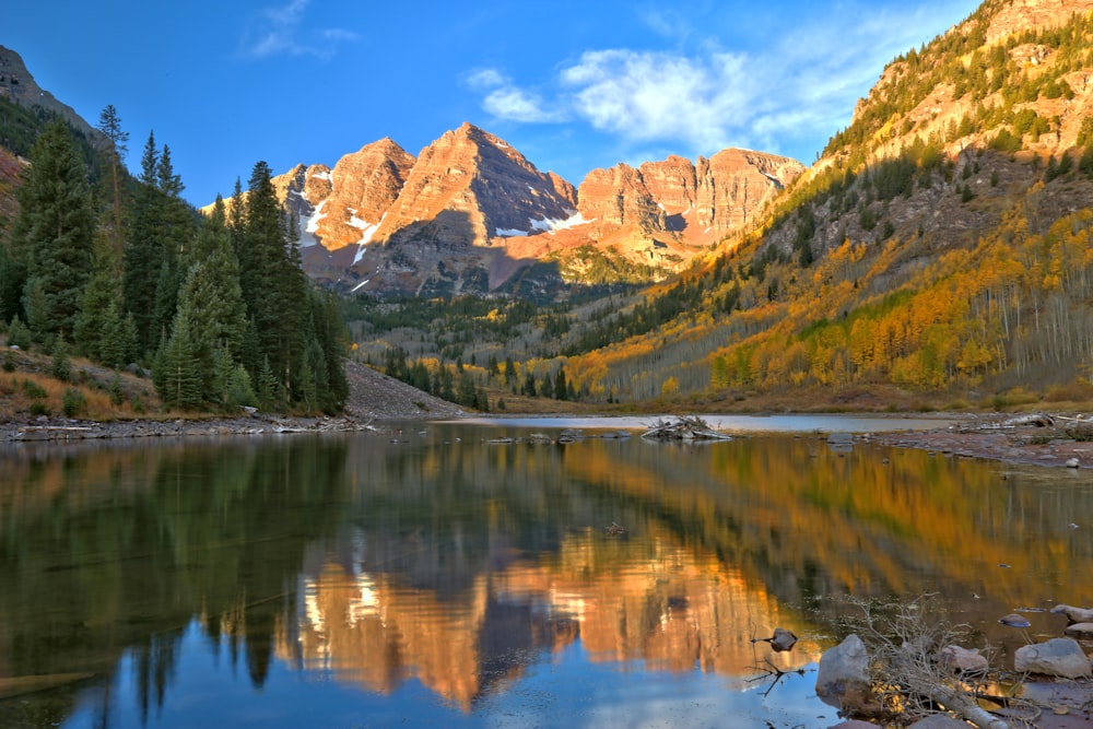 a mountain range with a lake surrounded by trees