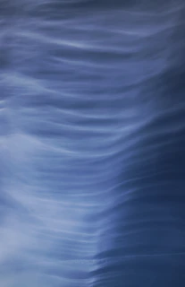 Abstract water ripples creating natural, flowing shapes in soft blues and greens