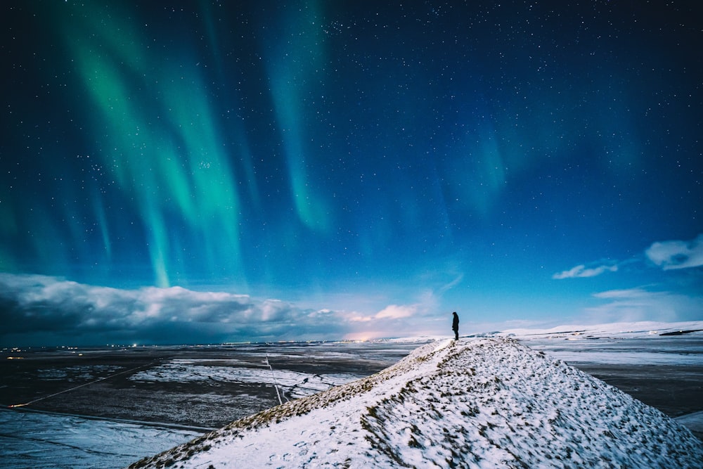 a person standing on top of a snow covered hill