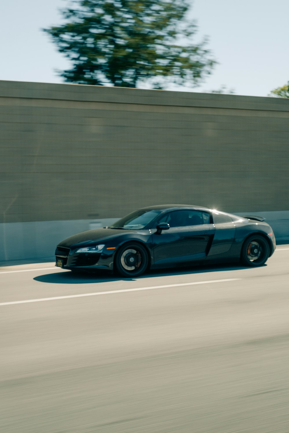 a black sports car driving down a highway