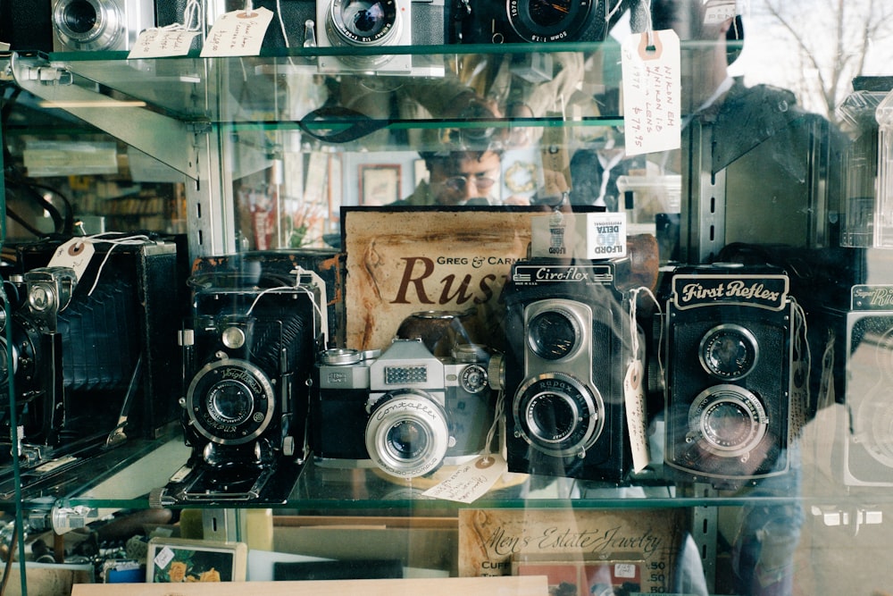 a bunch of old cameras sitting on a shelf