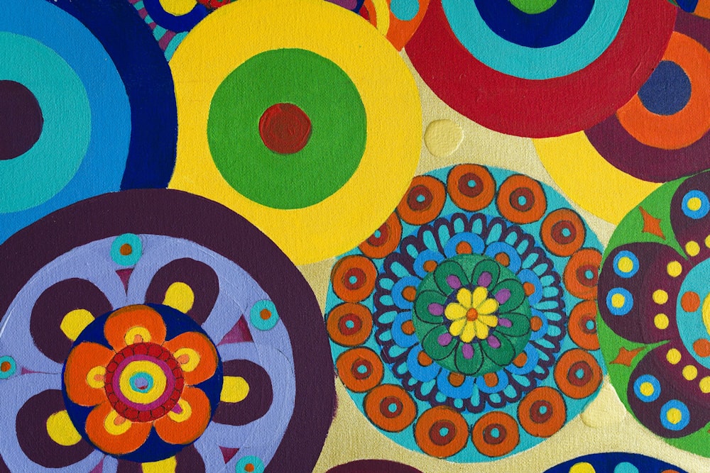 a painting of colorful circles on a yellow background