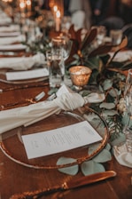 a wooden table topped with plates and glasses