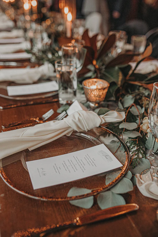 A wooden table laid with plates and glasses