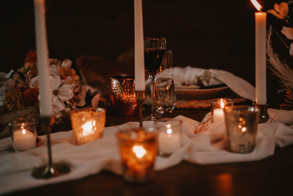 a table topped with candles and plates of food