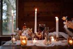 An intimate birthday party setup featuring crisp parchment table settings and warm candles.