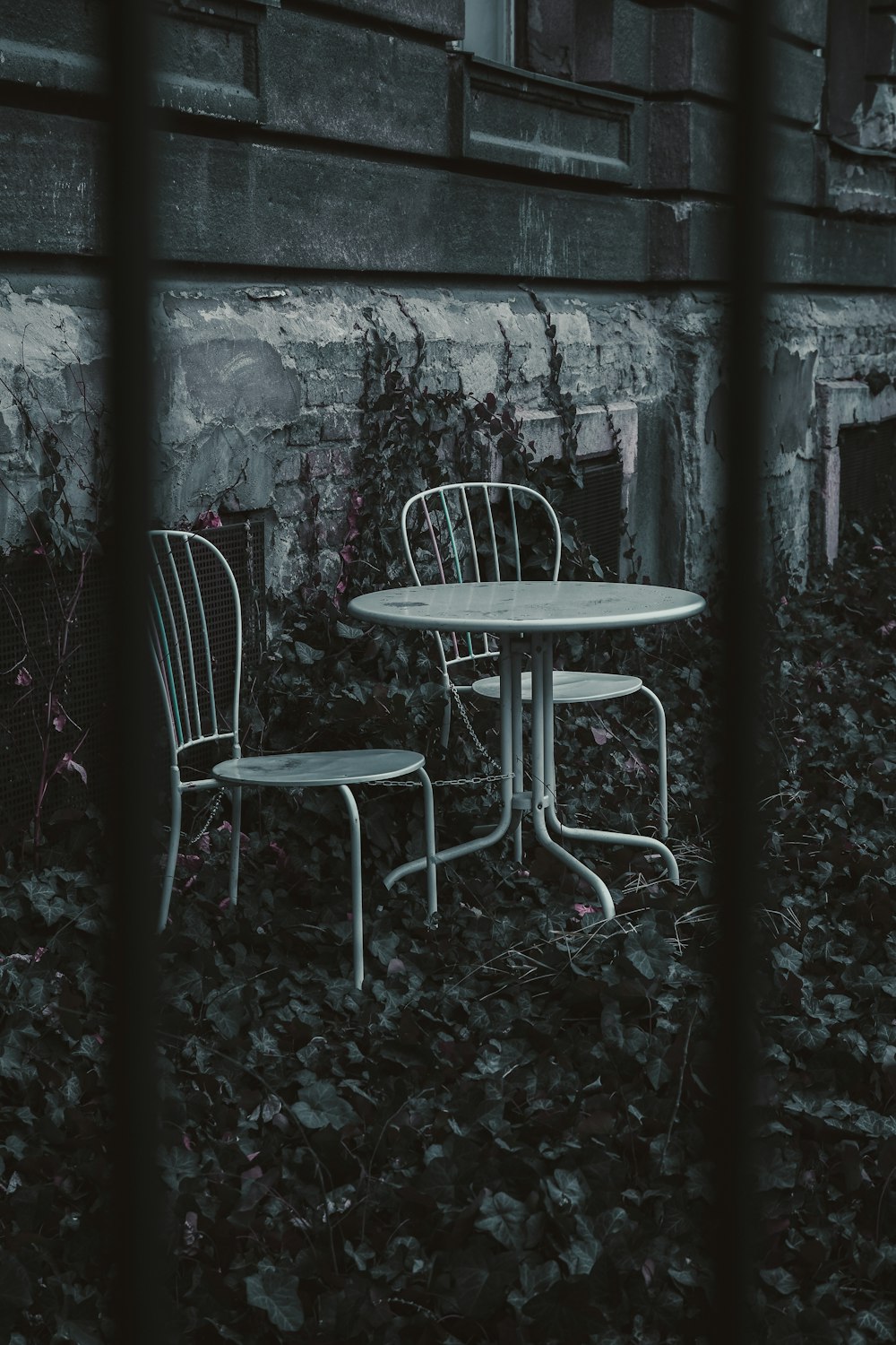 two white chairs and a table in front of a building