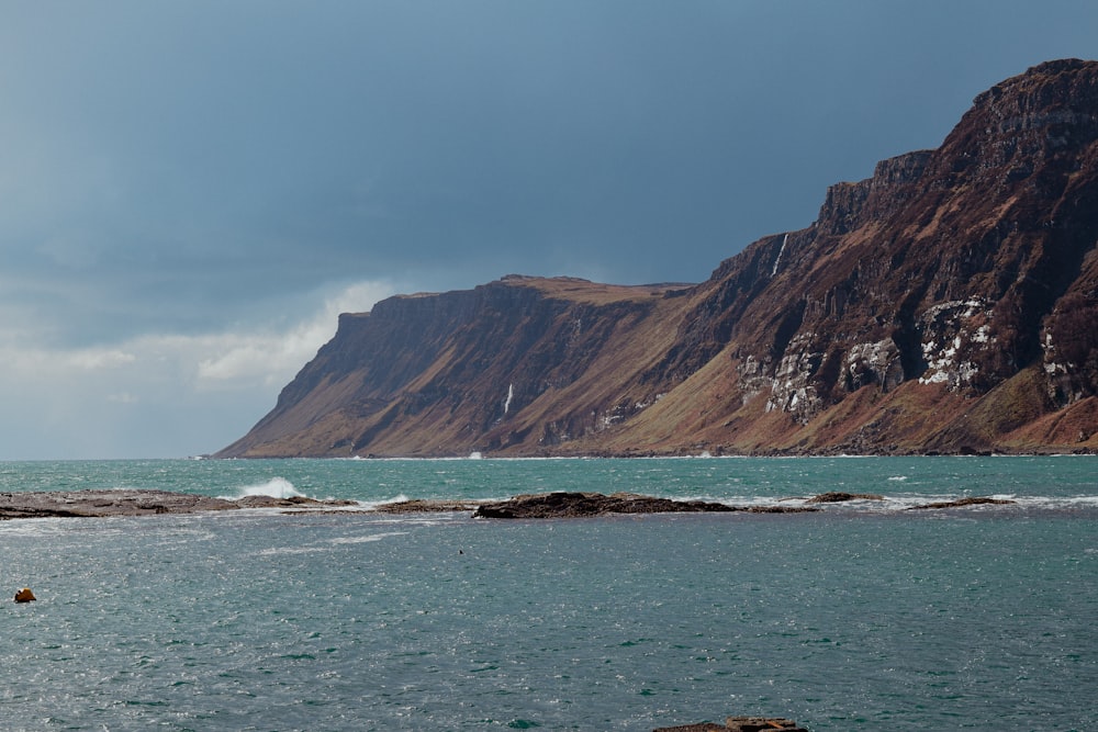 a large body of water with a mountain in the background