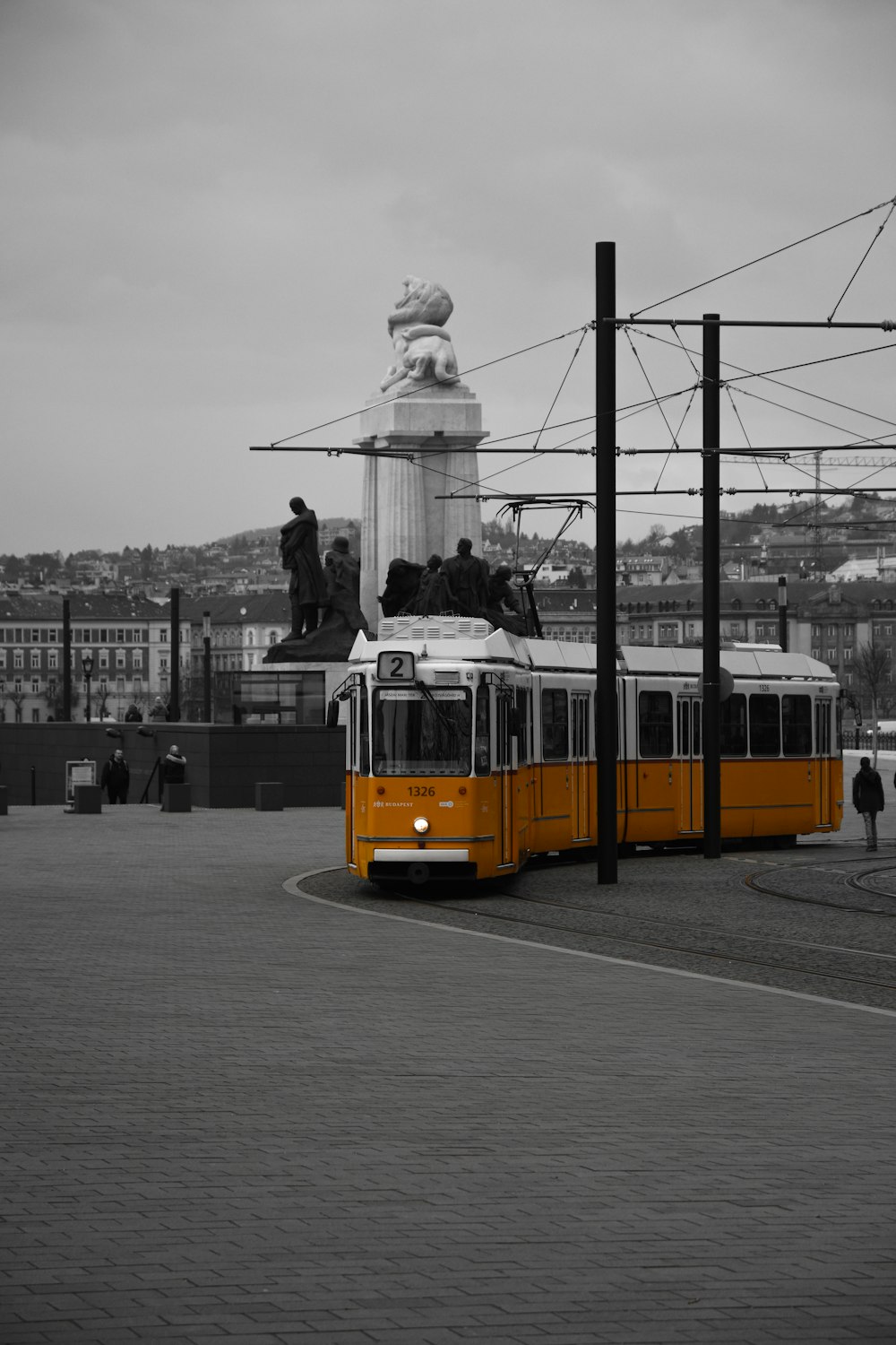 an orange and white trolley on a city street