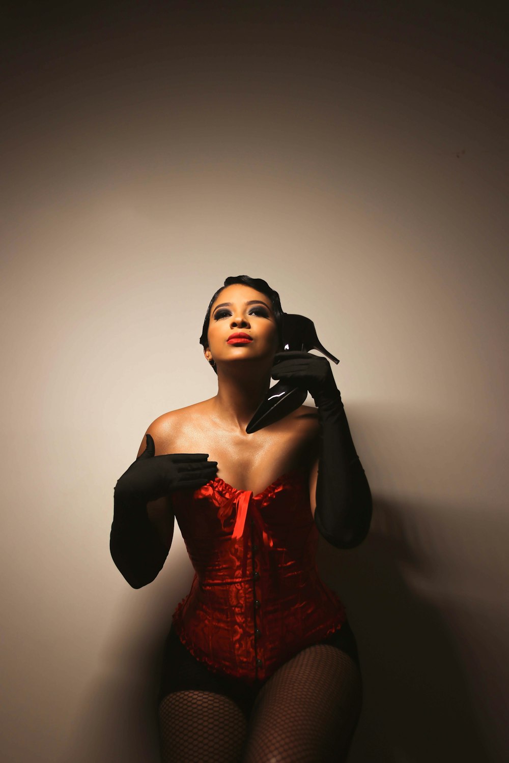a woman in a red corset and black gloves
