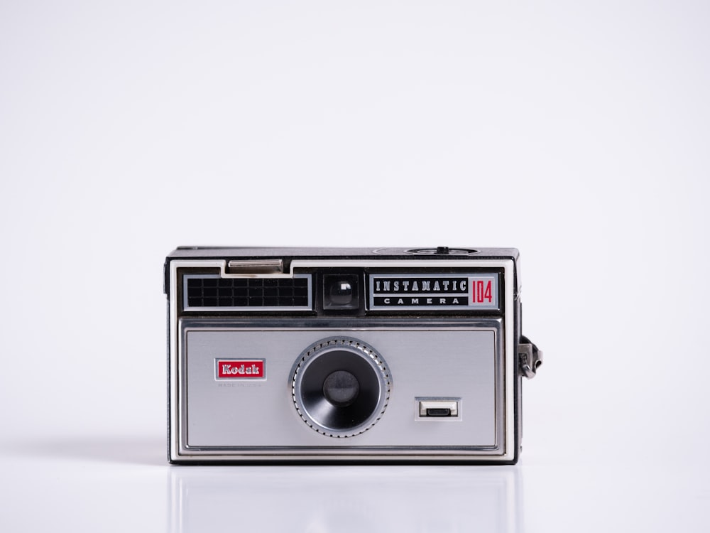 an old fashioned camera sitting on a white surface