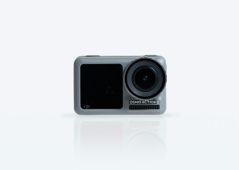 Compact black action camera photographed on a plain white surface