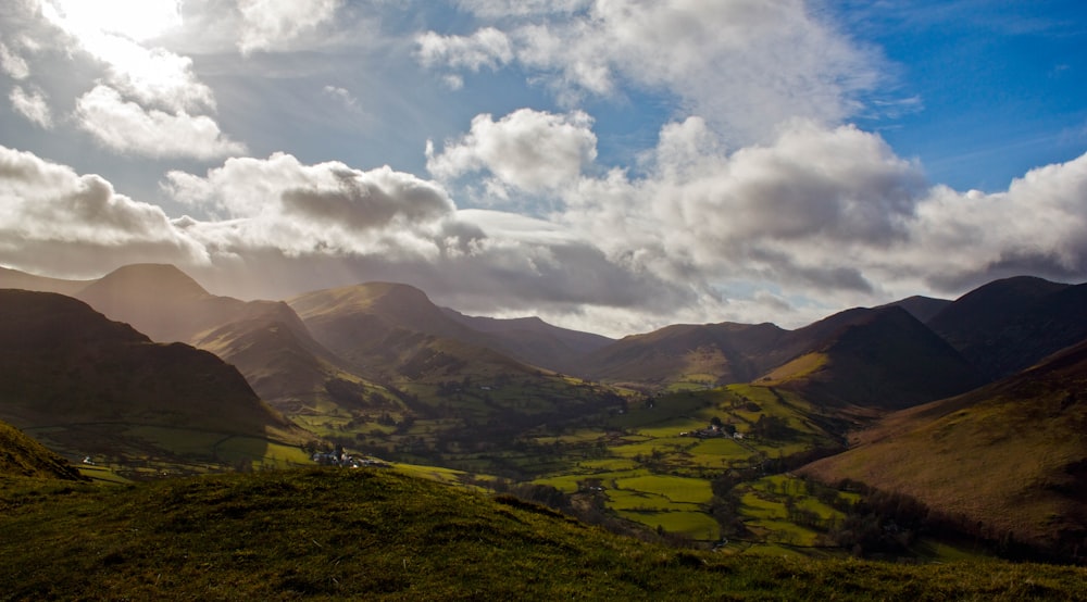 a scenic view of a valley with mountains in the background