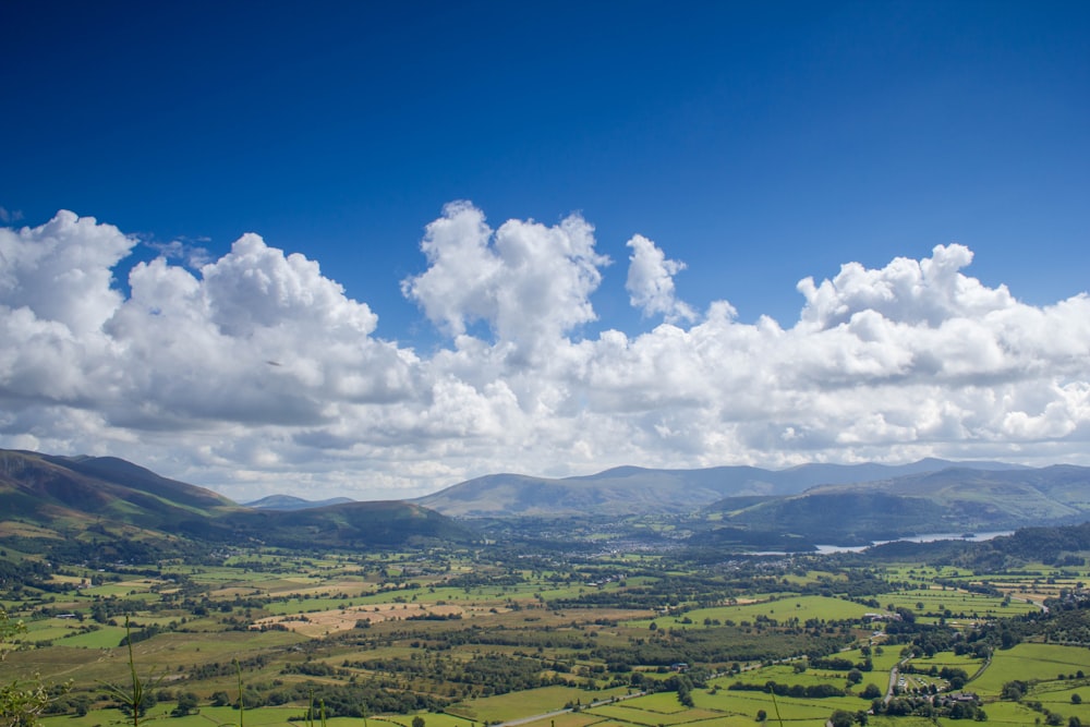 a scenic view of a valley with mountains in the background