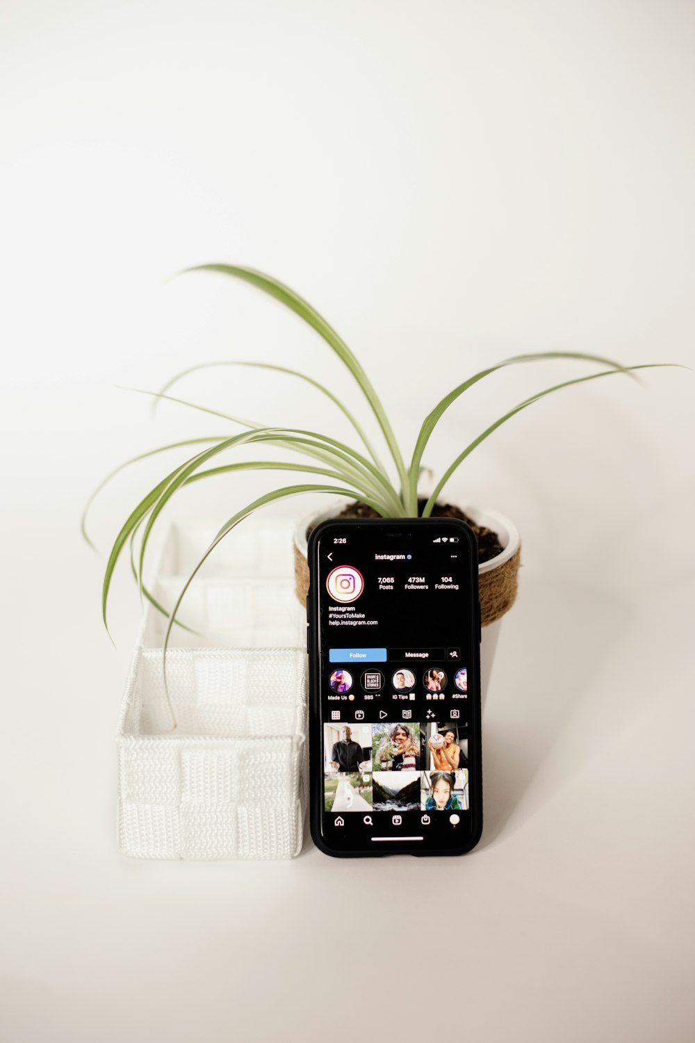 a cell phone sitting next to a potted plant