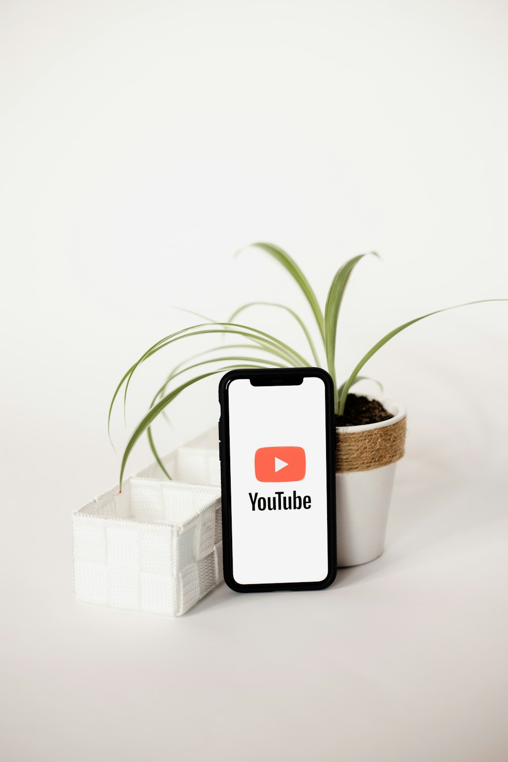 a cell phone sitting next to a potted plant