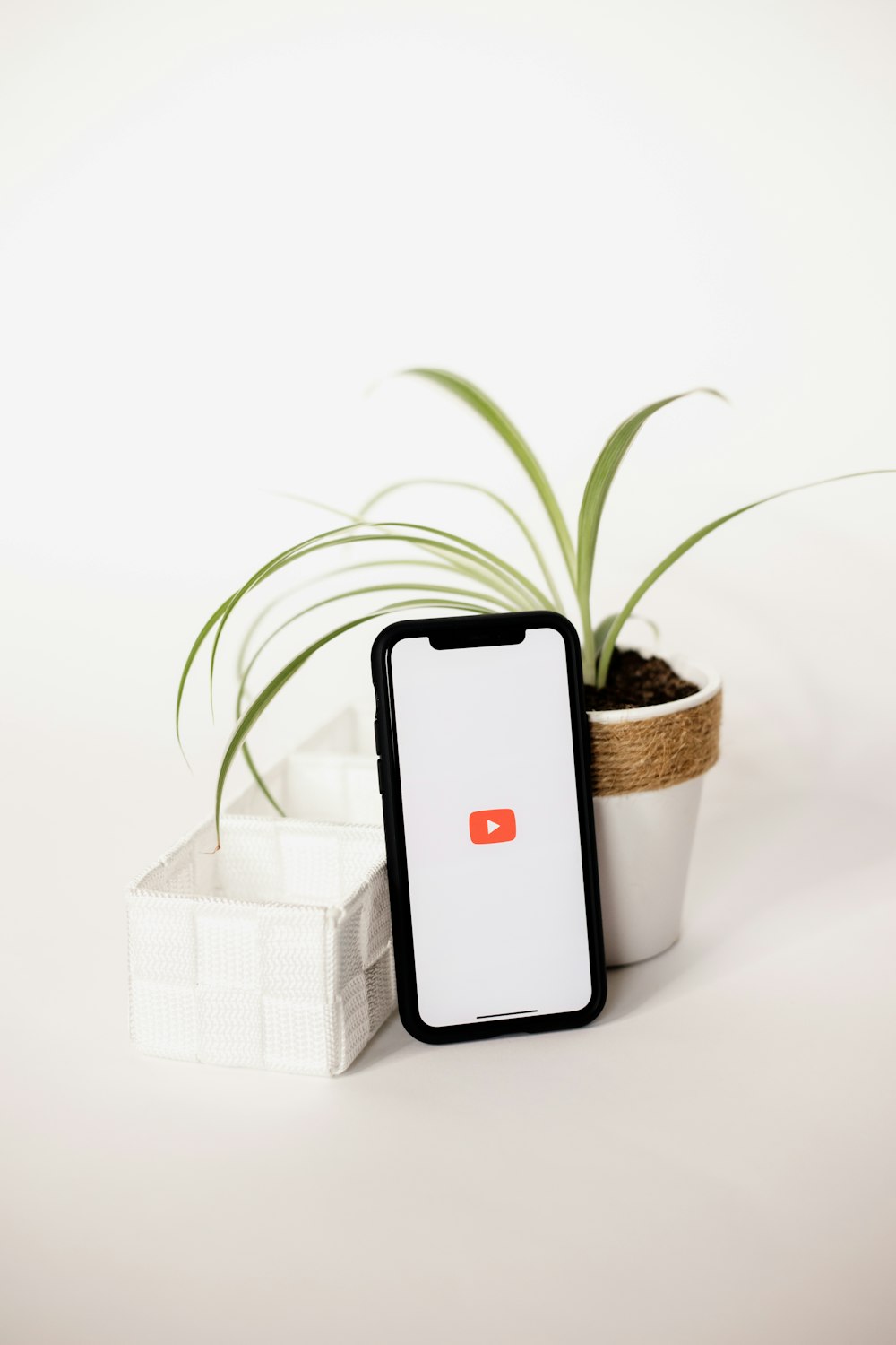 a cell phone sitting next to a potted plant