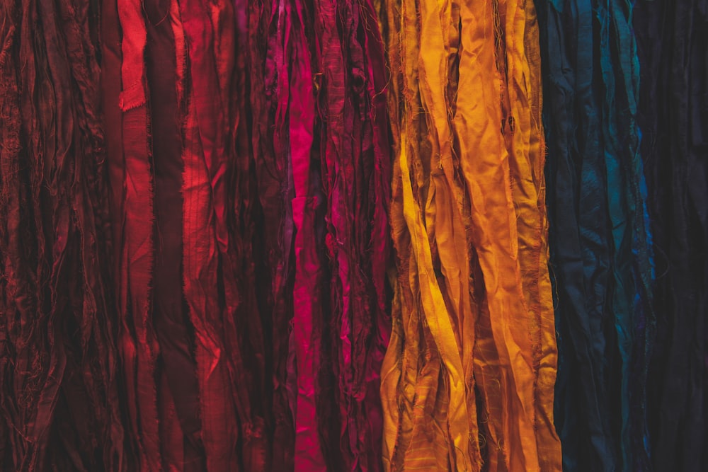 a group of different colored ribbons hanging on a wall