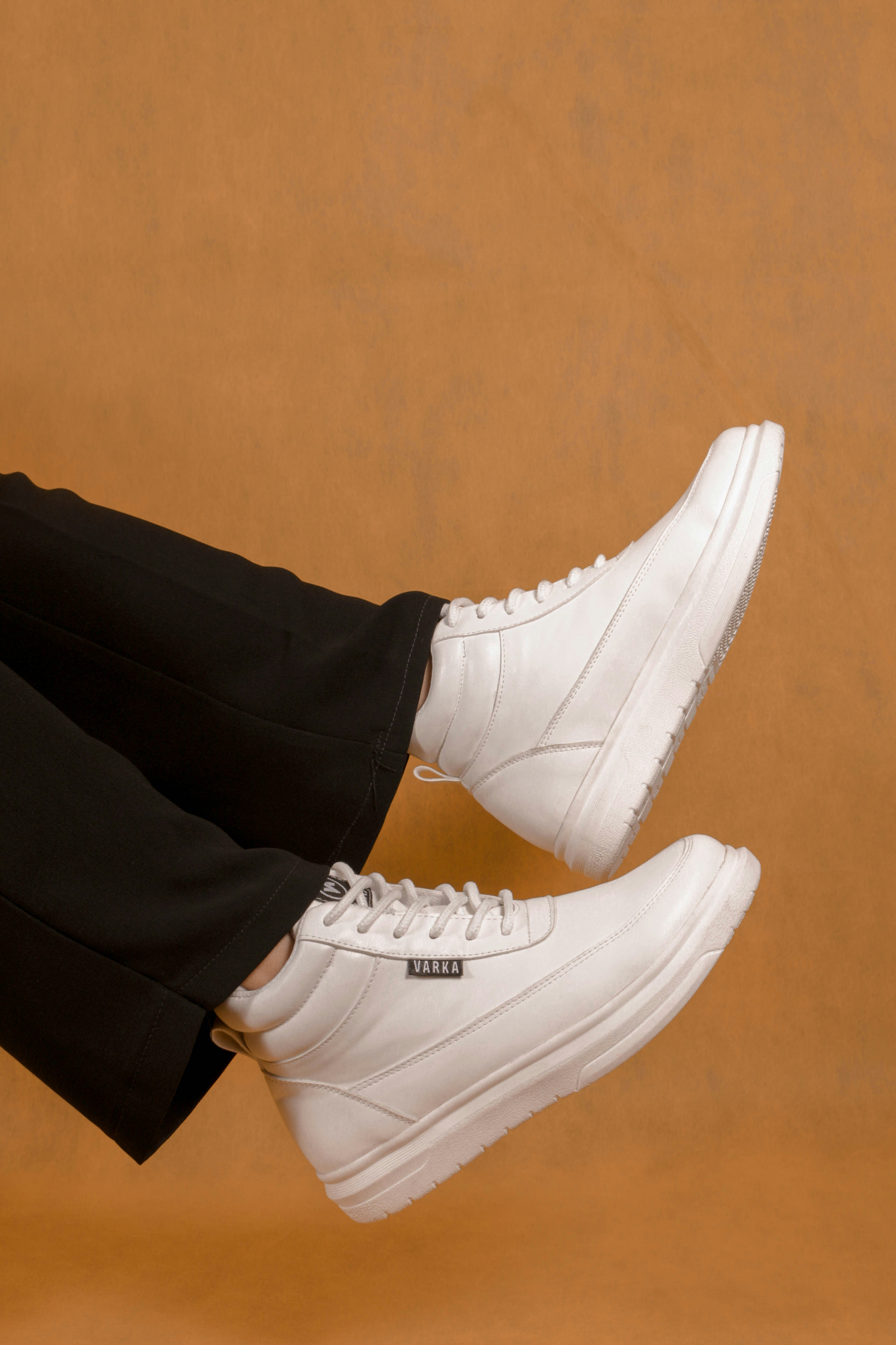 How to Style Sneakers for Dressy Occasions Without Losing Elegance – a person sitting on a chair wearing white sneakers