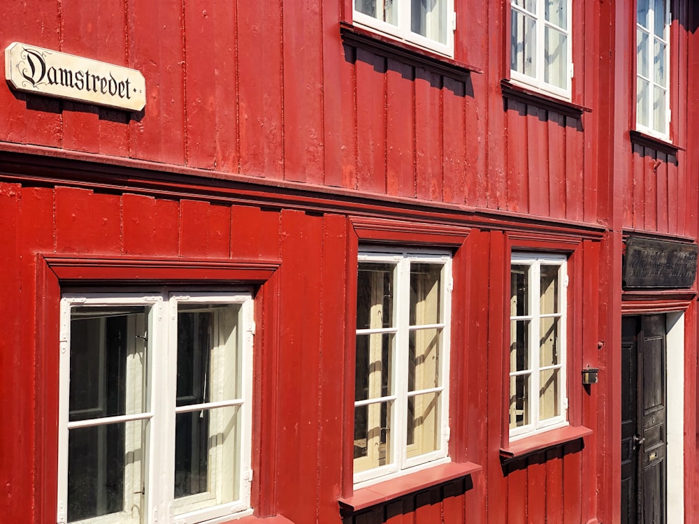 a red building with windows and a sign on it