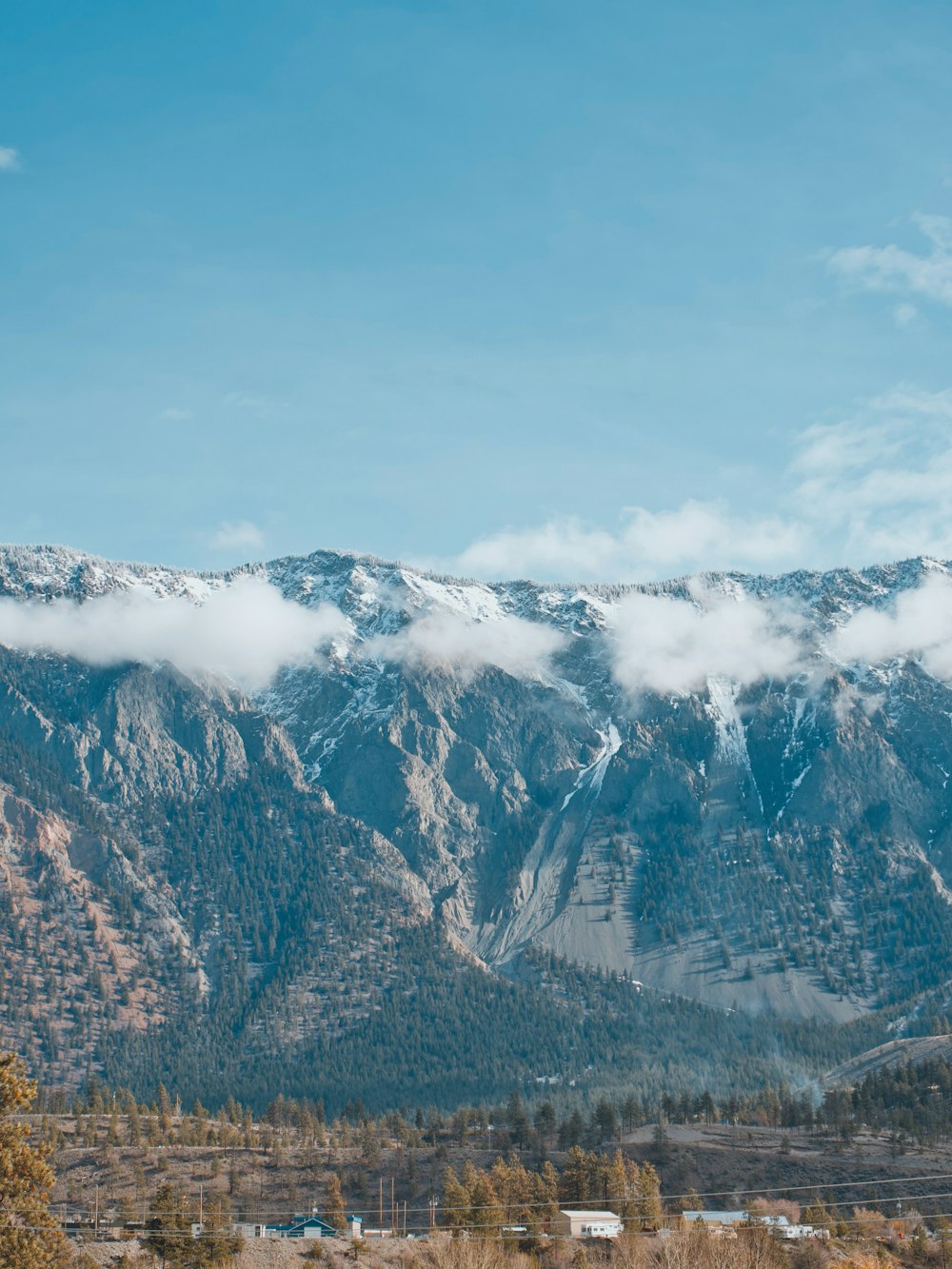 the mountains are covered in snow and clouds