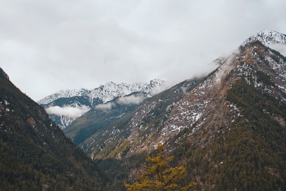 the mountains are covered in snow and clouds