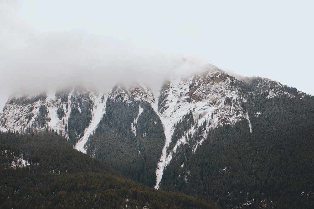 a mountain covered in snow and clouds