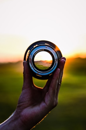 Close-up of a camera lens capturing golden hour light at a club outdoor shoot