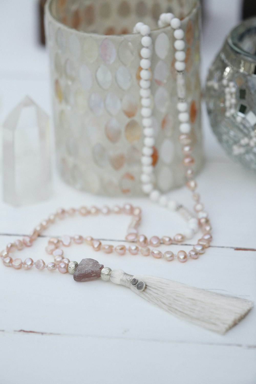 a beaded necklace with a tassel on a table