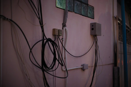 a bunch of wires hanging on the side of a building