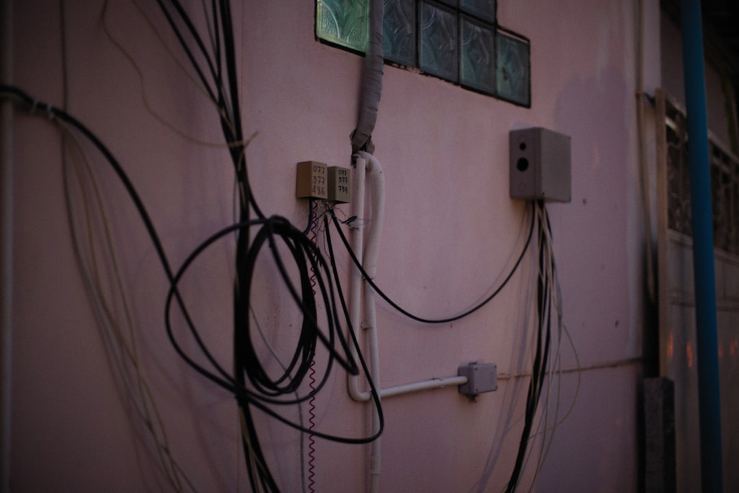 掃除機 コードレス 充電できない a bunch of wires hanging on the side of a building