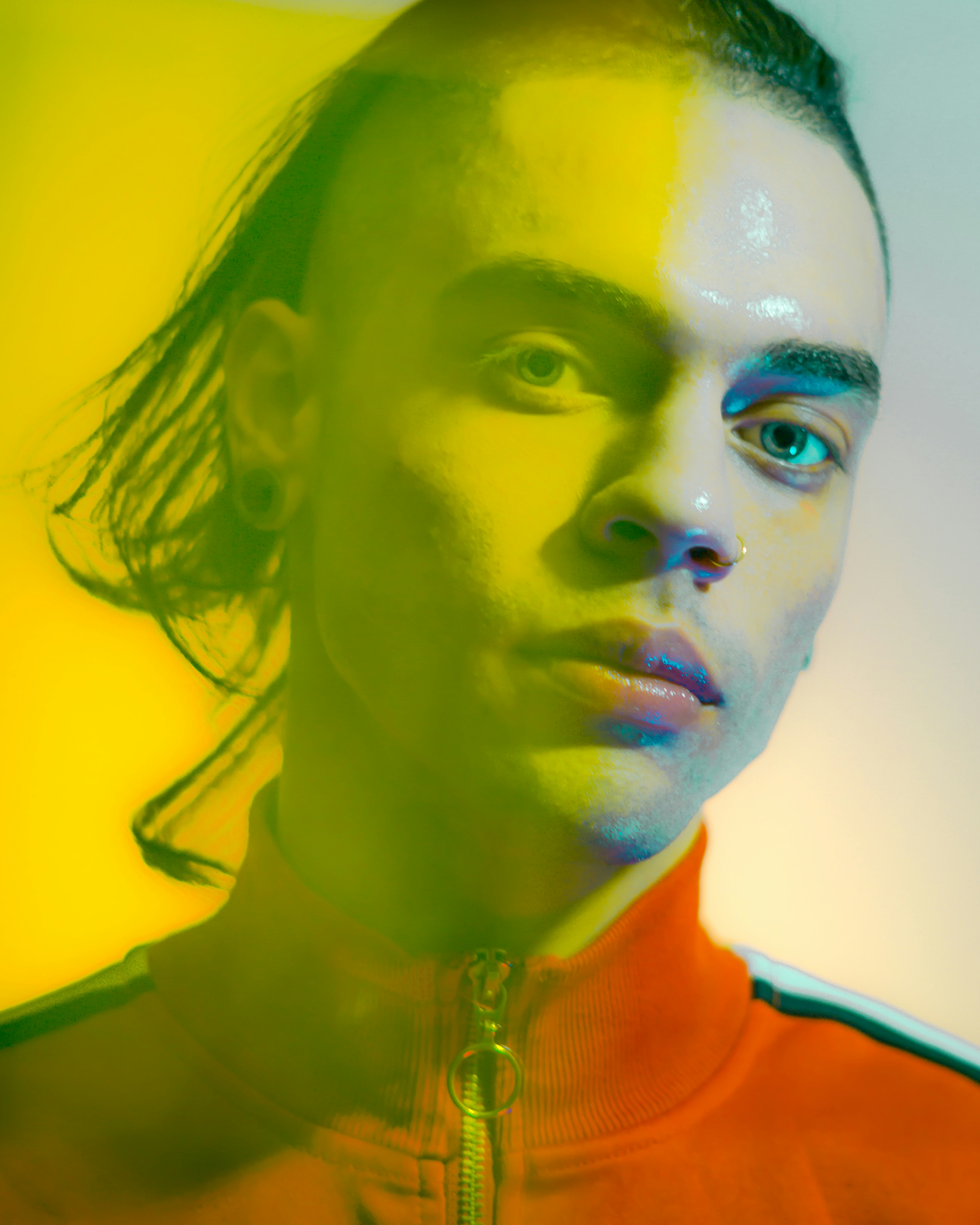 a man with long hair wearing an orange jacket