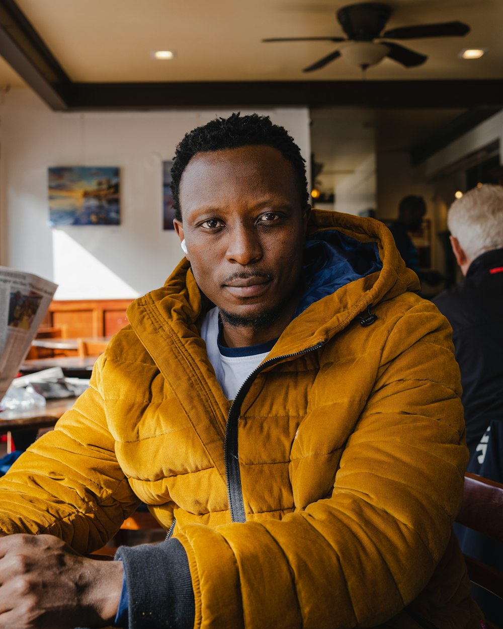 a man in a yellow jacket sitting at a table