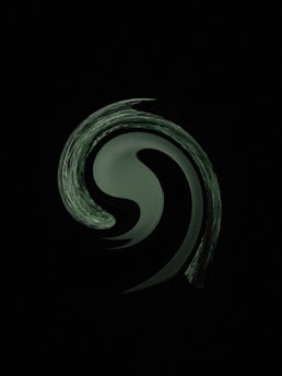 a black and white photo of a swirl in the dark