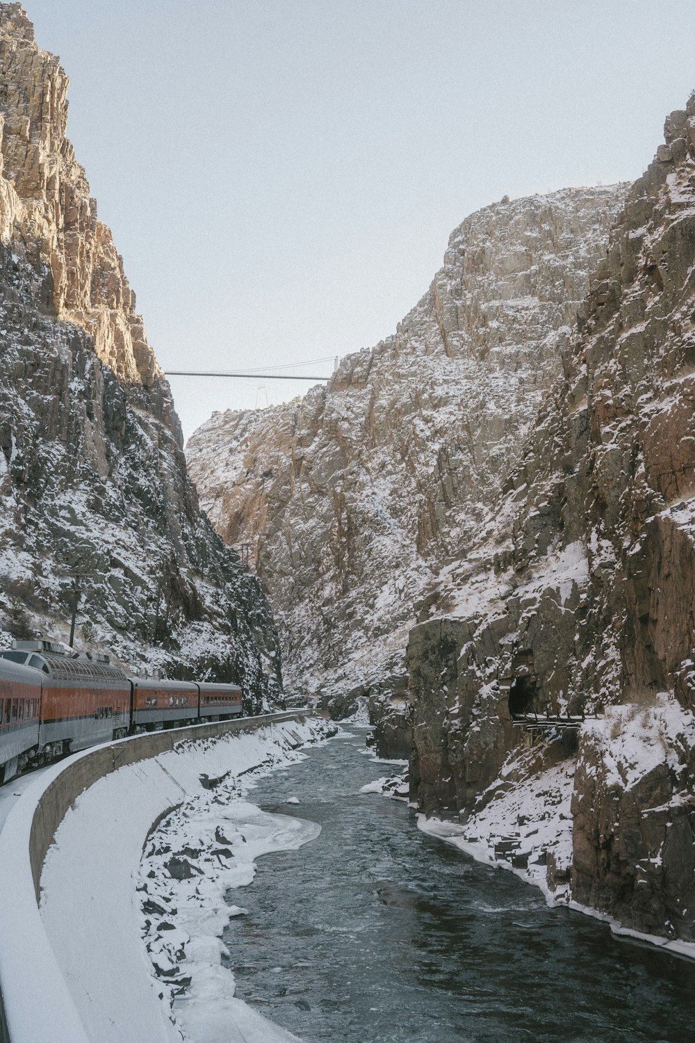 a train traveling through a snow covered mountain side