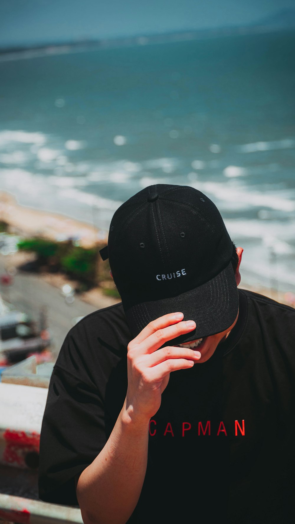 a man sitting on a ledge looking at the ocean