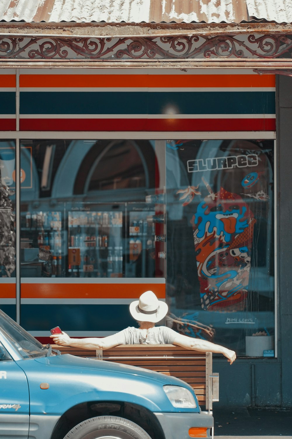 a person laying on a bench in front of a store