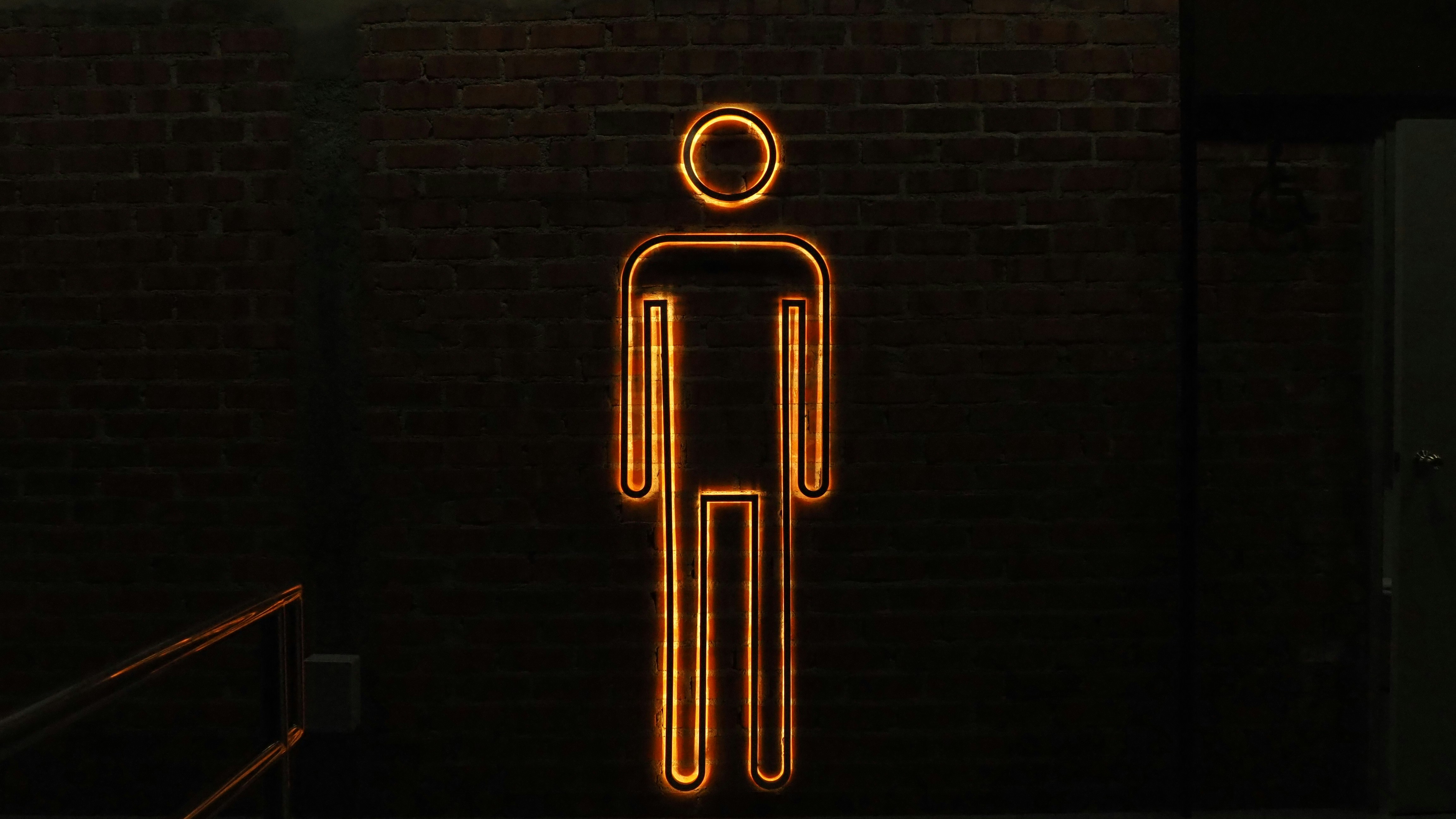 a neon sign of a man standing in a dark room