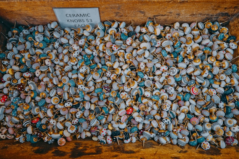 a pile of buttons sitting on top of a wooden table