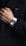 a man in a black jacket is wearing a white and black watch