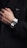 a man in a black jacket is wearing a white and black watch