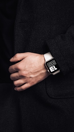 a person wearing a black and white watch on their wrist