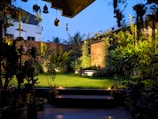 Peaceful outdoor garden area with sand and twilight sky in background.