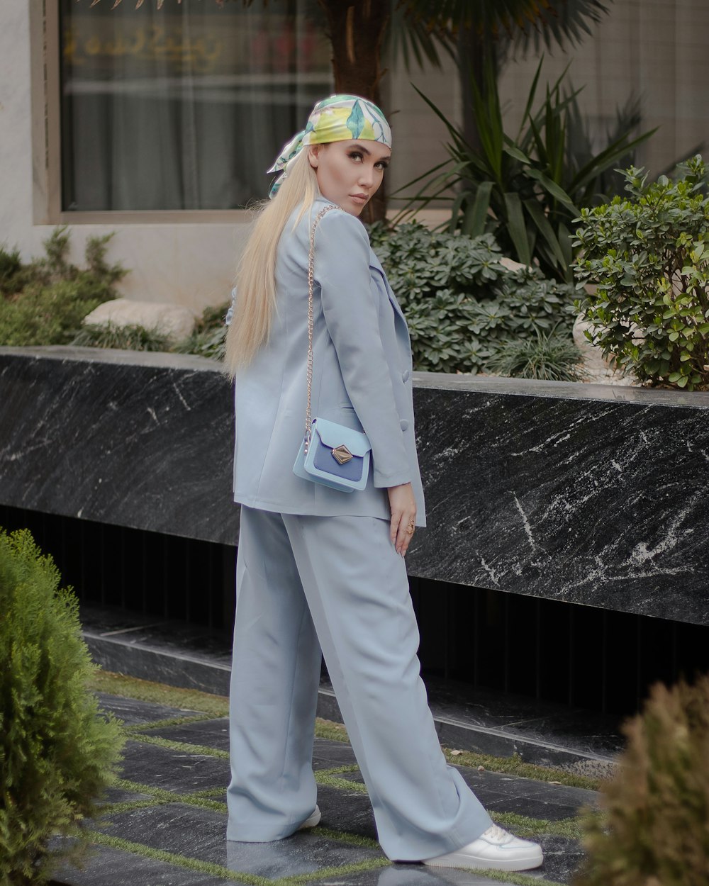 a woman in a blue suit is walking down the street