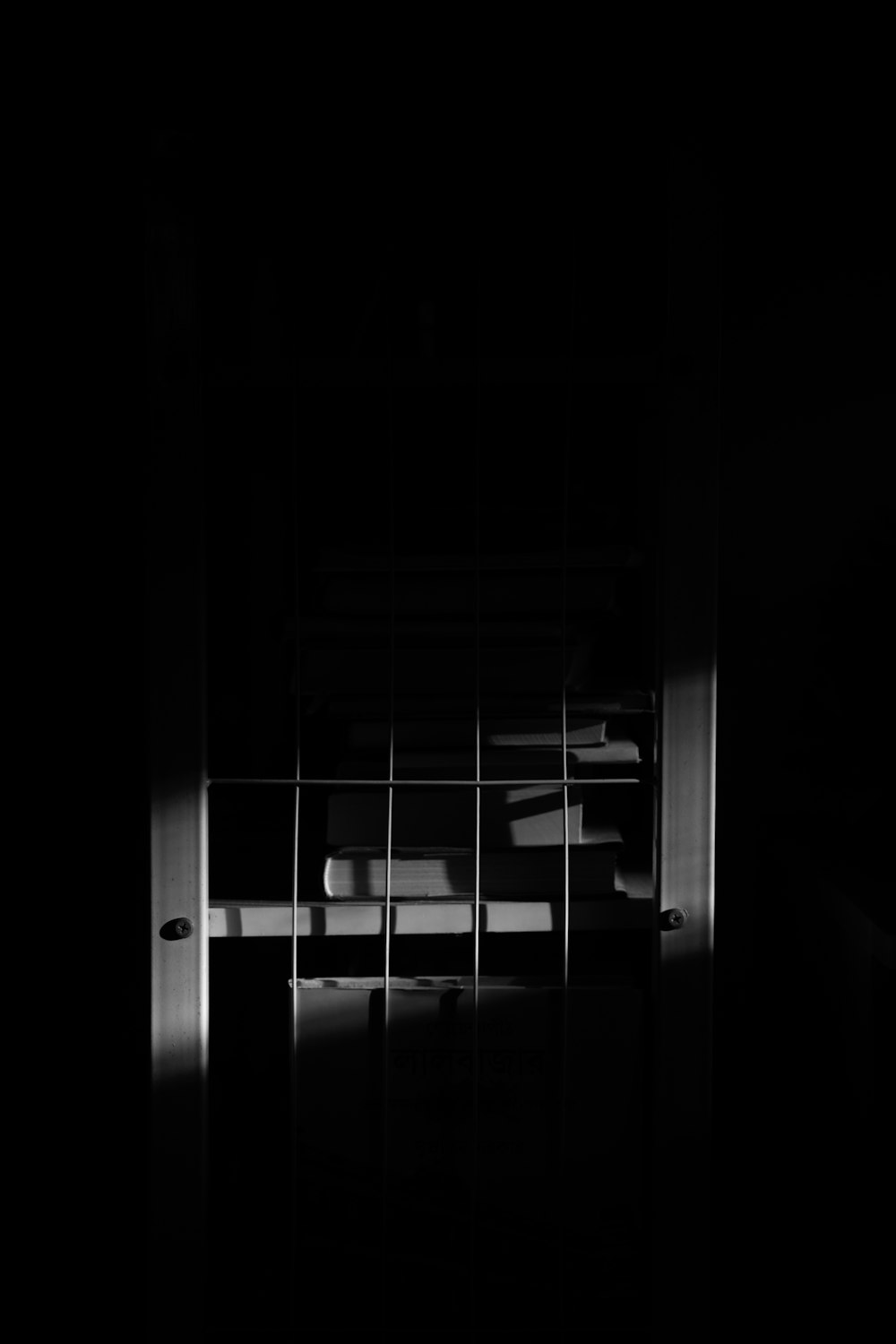 a black and white photo of a window in a dark room